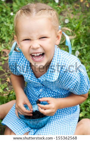Happy Child in Summer.  Beautiful Girl with Blackberry in the Garden. Happy Children. Healthy Kids. Spring Time. Vacation in the Countryside.  Healthy Nutrition.