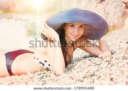 Beautiful woman lying on the beach at summer. Sun beams. Summer sun light, summer colors.