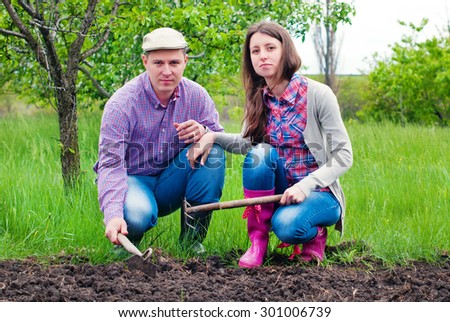 Family in the Garden resting after work. Woman and Man  Working in the Garden together. Healthy Lifestyle
