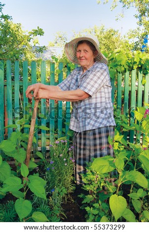 old woman in hat working in the garden