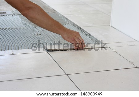 A Tiler Laying A New Tiles To An Outdoor Patio