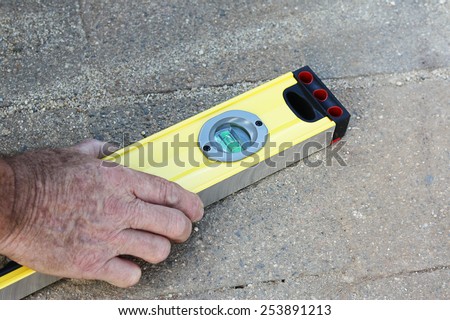a male hand holding a level tool