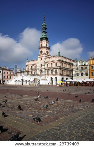 Poland, medieval town Zamoscie marketplace square with doves on first plane