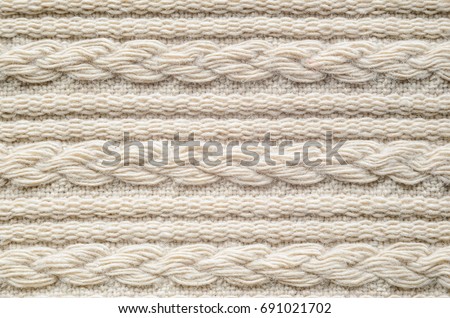 Pigtails on Beige Knitwear Fabric Texture. Machine Knitting Texture Macro Snapshot. Beige Knitted Background.