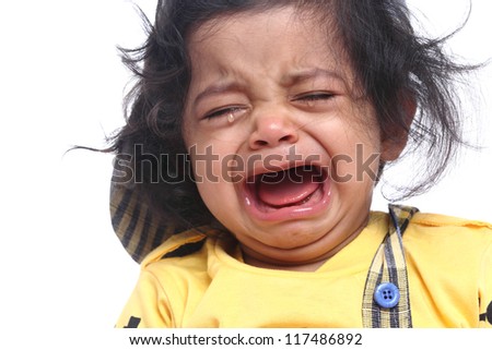 Portrait of cute Indian child crying on white background. - stock photo