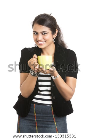 Petty Indian girl posing with tea cup in studio background.