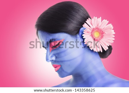 Pretty Indian girl with face painting in studio shot.