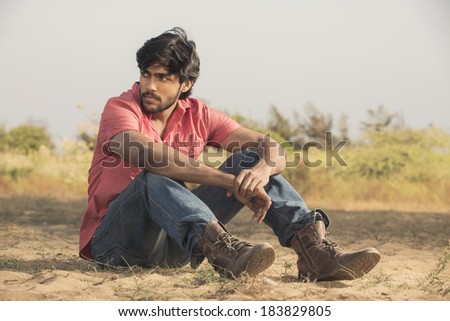 Handsome Indian male model in outdoor background.