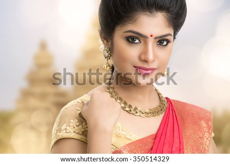 Young traditional Indian woman portrait on temple background.