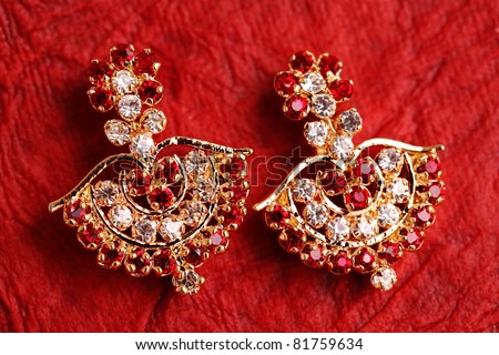 earring on textured red background.
