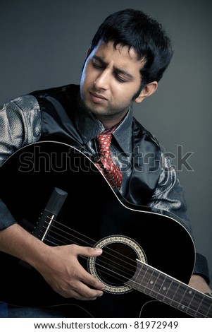 An Indian guitar player - isolated  on grey.