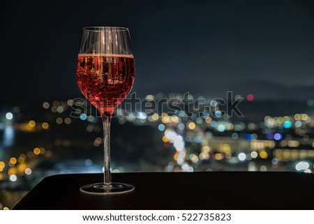 festive celebration background and texture ,  cocktail glass of rose wine, bottle of wine   on dark stone table  blurred bokeh background,