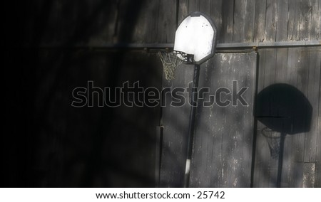 B-ball goal and shadow on a barn. Left side blacked out for print area.
