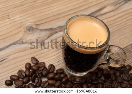 Glass Cup of Espresso Coffee on Wooden Table With Coffee Beans - Shallow Depth of Field