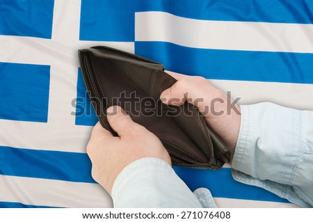 Financial Crisis in Greece - Man\'s Hand With Empty Wallet and Greek flag