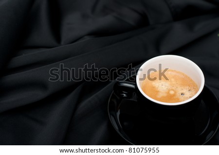 Cup of Espresso Coffee on Black Silky Drapery