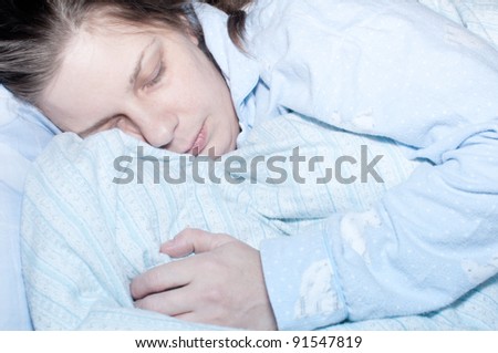 Sleeping Ill Woman in Bed in Shades of Blue