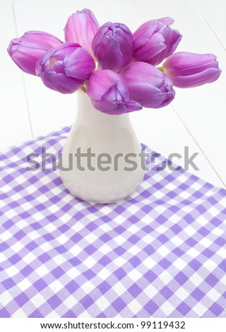 Violet Tulips in Vase on Violet Gingham Tablecloth on White Wooden Table