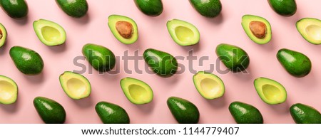 Avocado pattern on pink background. Top view. Banner. Pop art design, creative summer food concept. Green avocadoes, minimal flat lay style. Banner.