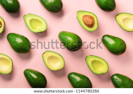 Avocado pattern on pink background. Top view. Banner. Pop art design, creative summer food concept. Green avocadoes, minimal flat lay style