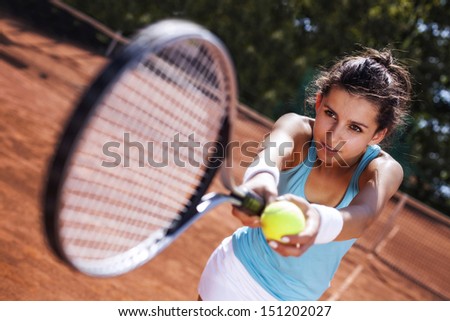 Young girl catching a ball in tennis court in pretty day