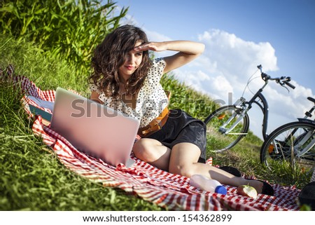 Women, picnic and computer! On grass in summer