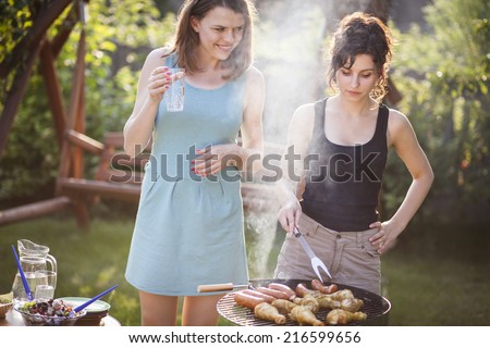 Two pretty girls making food on grill