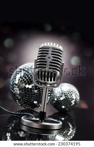 Professional silver microphone on a black glossy background