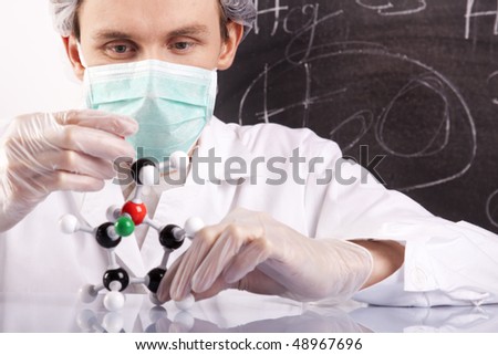 Scientist examine atoms, black table in background