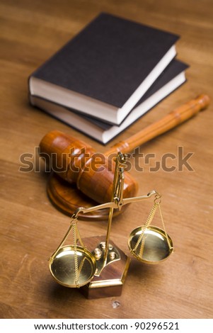 Scales of justice and gavel on desk with dark background