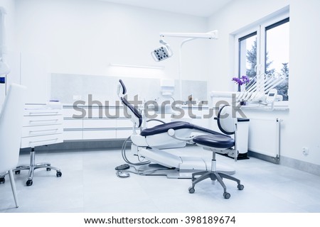 Modern dental practice. Dental chair and other accessories used by dentists in blue, medic light