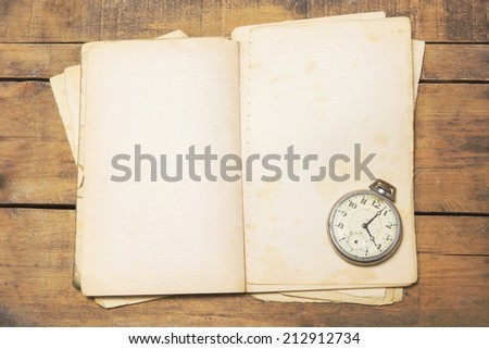 The old and broken pocket watch on the old book