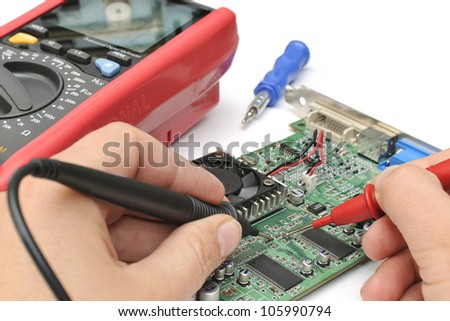 Close-up of a technicianÃ¢Â?Â?s hands with multimeter probes repairing a pc board