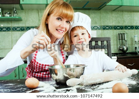Mom with son cooking and baking in kitchen