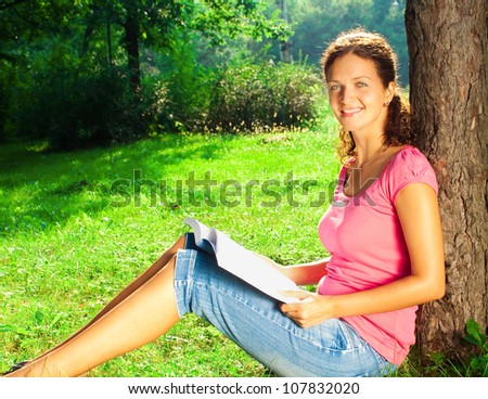 Young woman relaxing and reading book in park