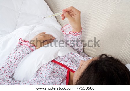 Young woman checking her body temperature, see similar pictures in my portfolio
