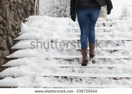 woman climbs the stairs in the snow