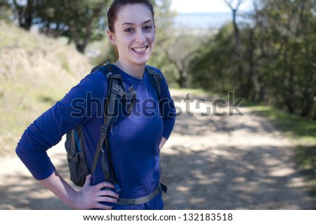 Hiker woman in blue long sleeve shirt looks at camera