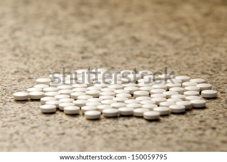 Flat group of generic white pills on hard surface