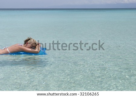 Picture of a woman floating on the smooth, crystal clear Caribbean waters. Shot at Bahia de las Aguilas beach in the Dominican Republic.