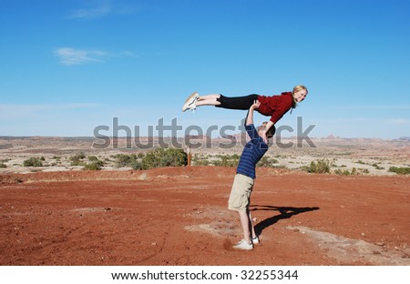 A couple performing a lift in the desert of Moab, UT.