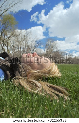 A young woman taking a nap in the park on a spring day.