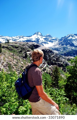 A man looking over a mountain valley during a hike