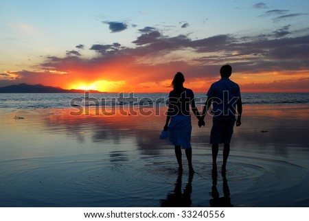 Two People Holding Hands In The Sunset. stock photo : A couple holding