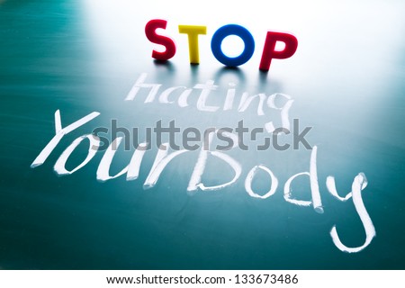Stop hating your body concept, colorful words on blackboard