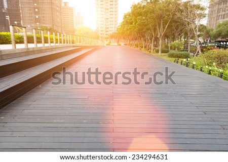 Deserted walkway and bench steps in an urban park surrounded by high-rise commercial buildings , low angle view