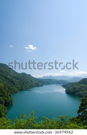 tranquil lake under sunny sky, and surround by forests.