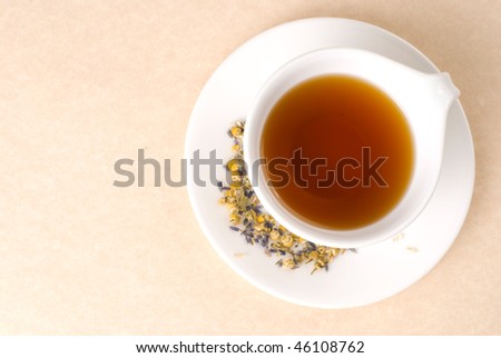 Red tea in white ceramic cup with flower decoration.