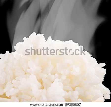 Hot cooked rice with smog on black background, Chinese food.