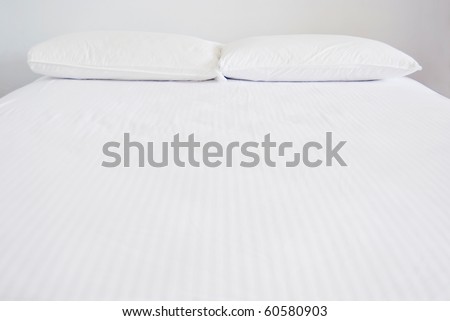 White pillows and bed in white bedroom